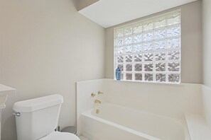 Bathtub, hair dryer, towels, shampoo