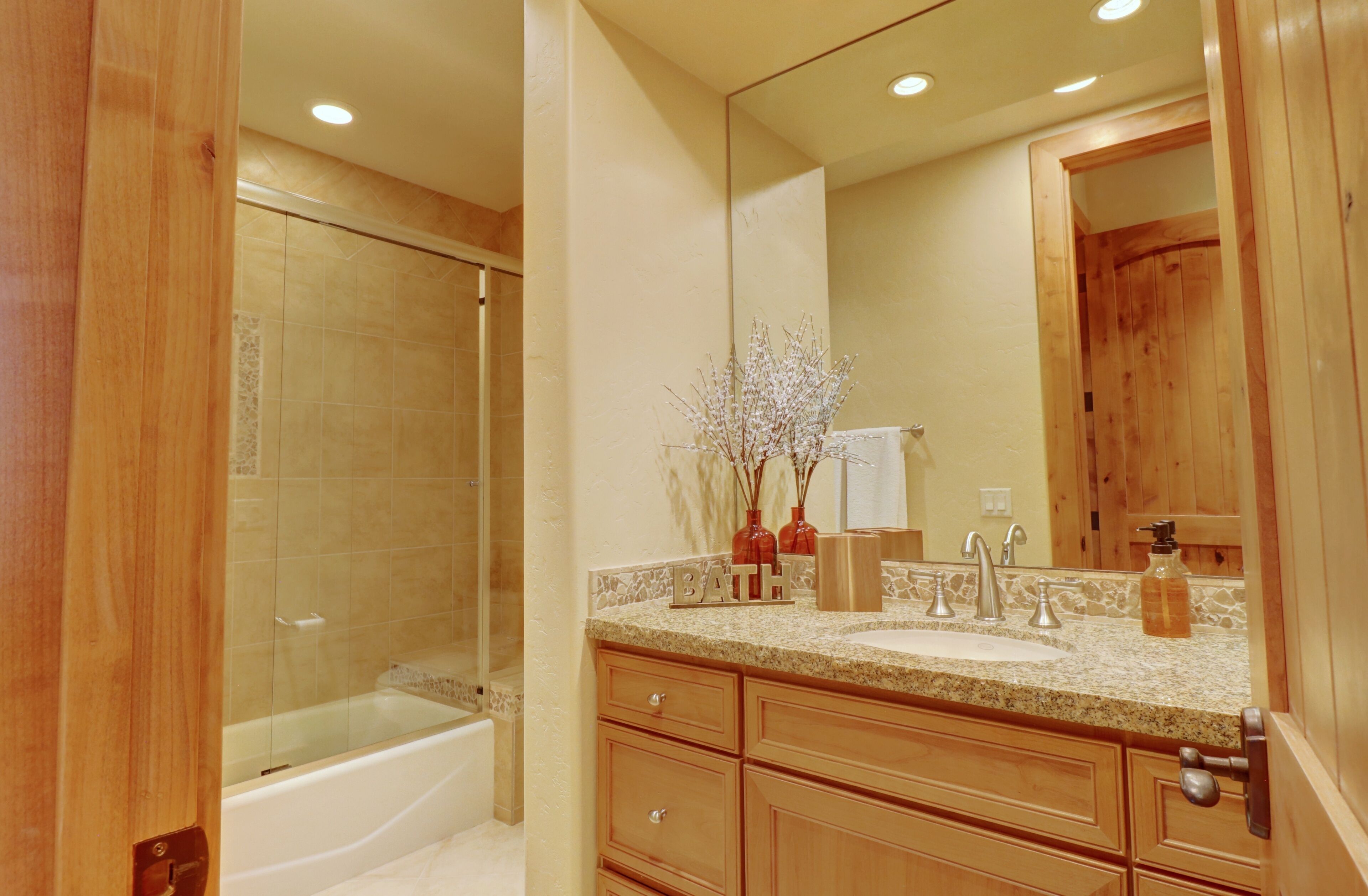 A bathroom with a bathtub, a sink, and a mirror.