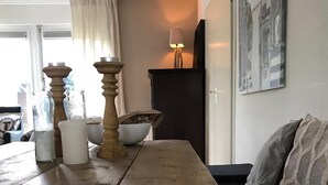 A wooden dining table with a bowl and candles.