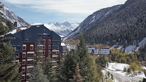 A mountain resort with modern buildings, a winding road, and snow-covered peaks. - Marcatosa by FeelFree Rentals (Baqueira)