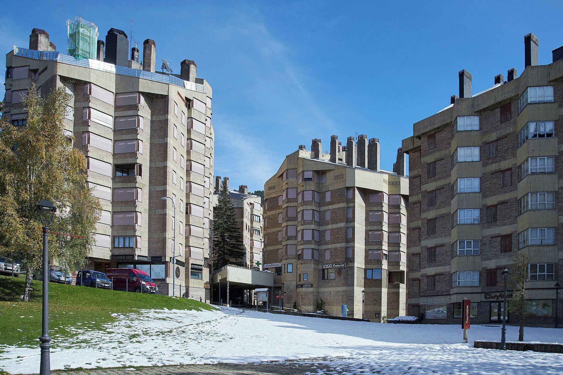 Um edifício residencial de vários andares com telhado plano e várias chaminés.