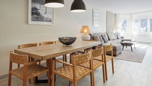 A dining area with a wooden table and woven chairs, a sofa, and a coffee table in a modern living room. - Marcatosa by FeelFree Rentals (Baqueira)