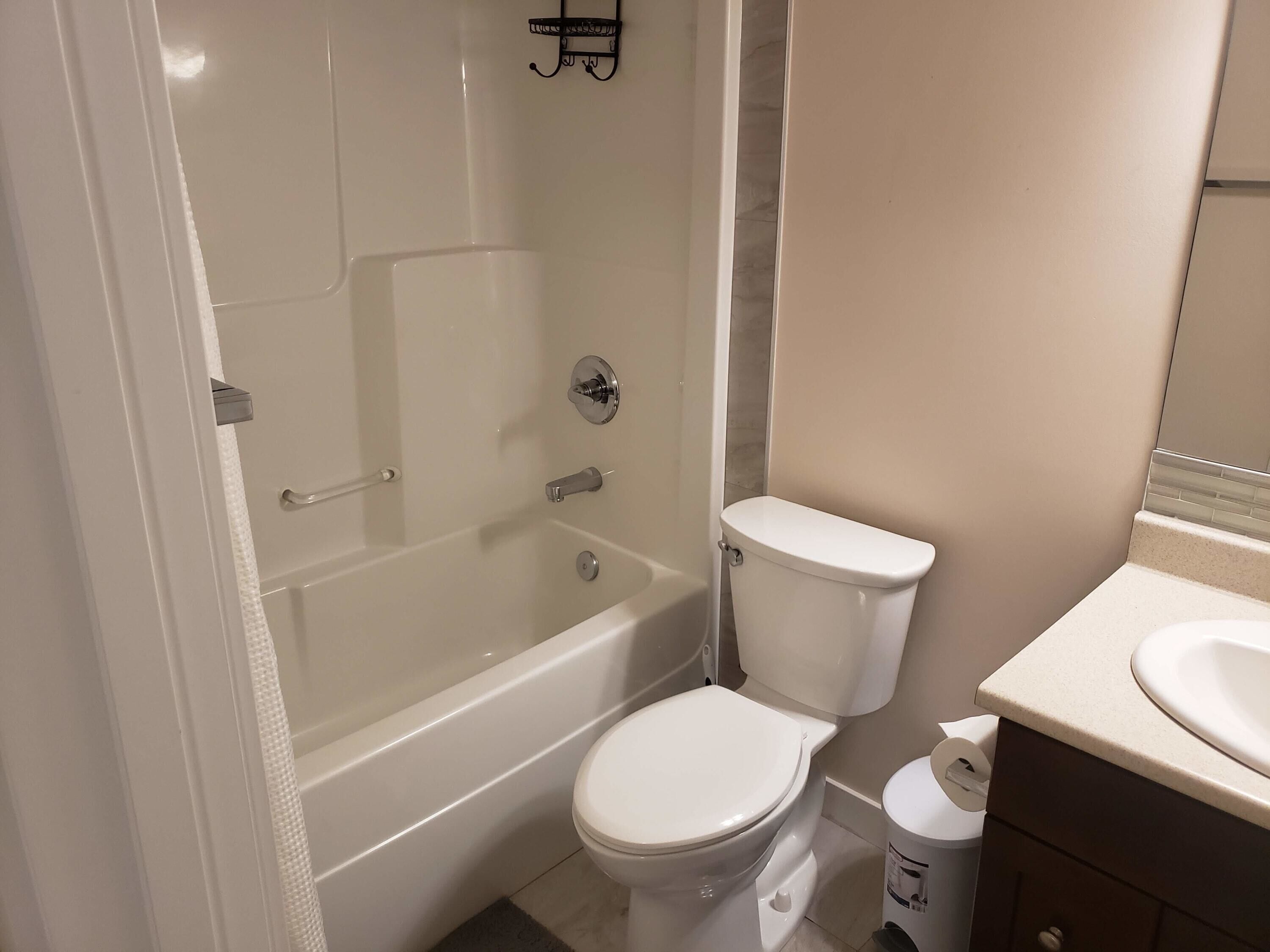 A bathroom with a bathtub, toilet, and sink.