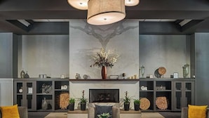 Un vestíbulo moderno con chimenea, dos sofás y una mesa de centro.