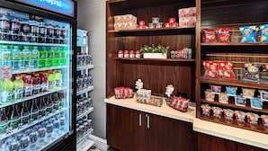 Un refrigerador lleno de bebidas y estantes con aperitivos y condimentos.