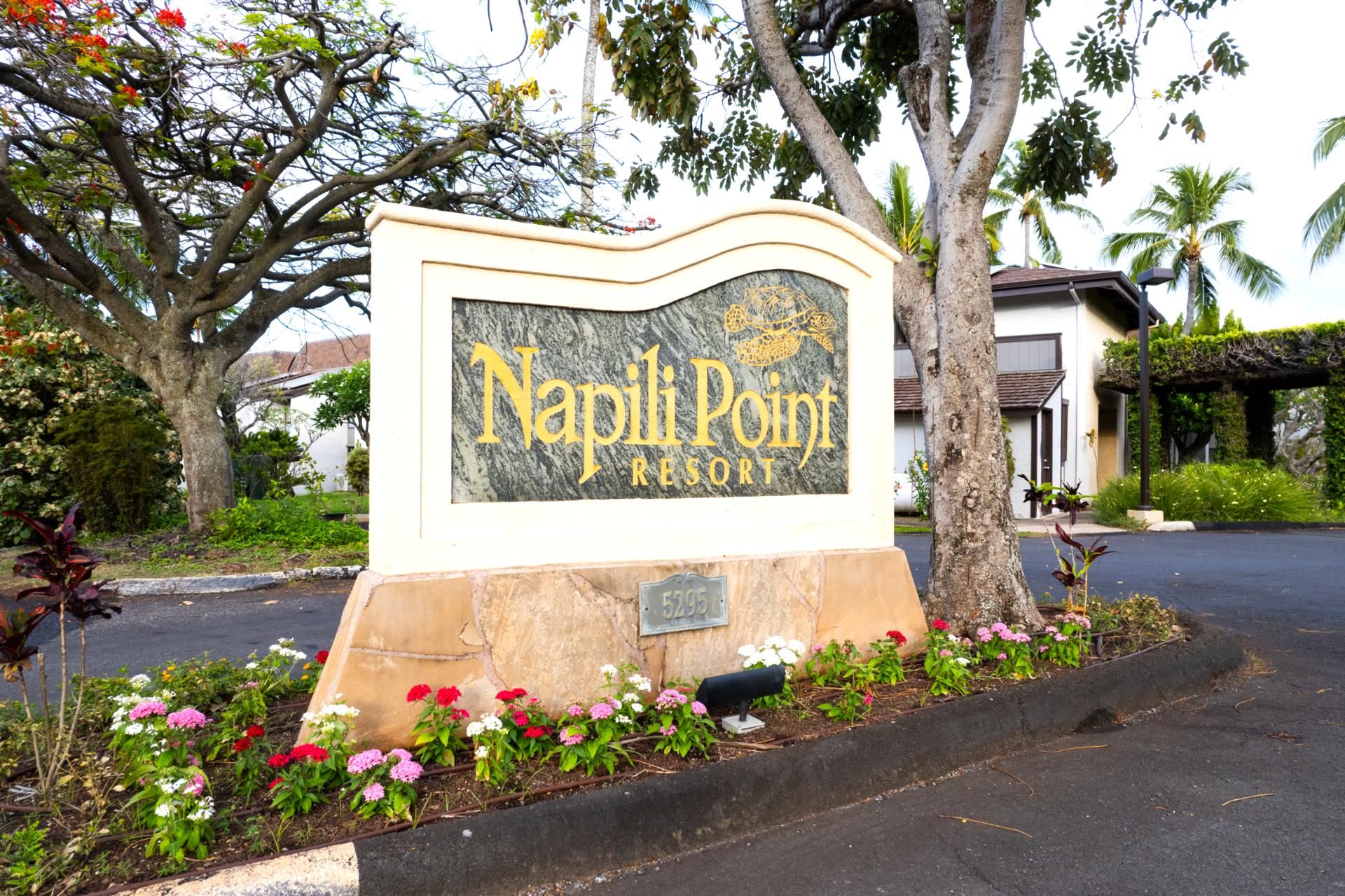 Un panneau indiquant l’emplacement du Napoli Point Resort, avec une base en pierre et un sommet en marbre.