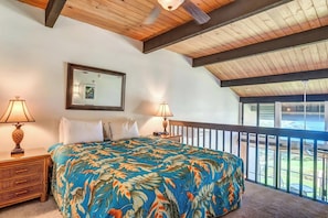 Ein Schlafzimmer mit einem großen Bett, zwei Nachttischlampen, einem Spiegel und einem Balkon mit Blick.