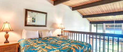 Un dormitorio con cama, dos mesitas de noche, un espejo y un balcón con vistas.