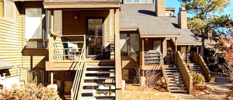 A two-story wooden house with a front porch, a staircase, and a garage.