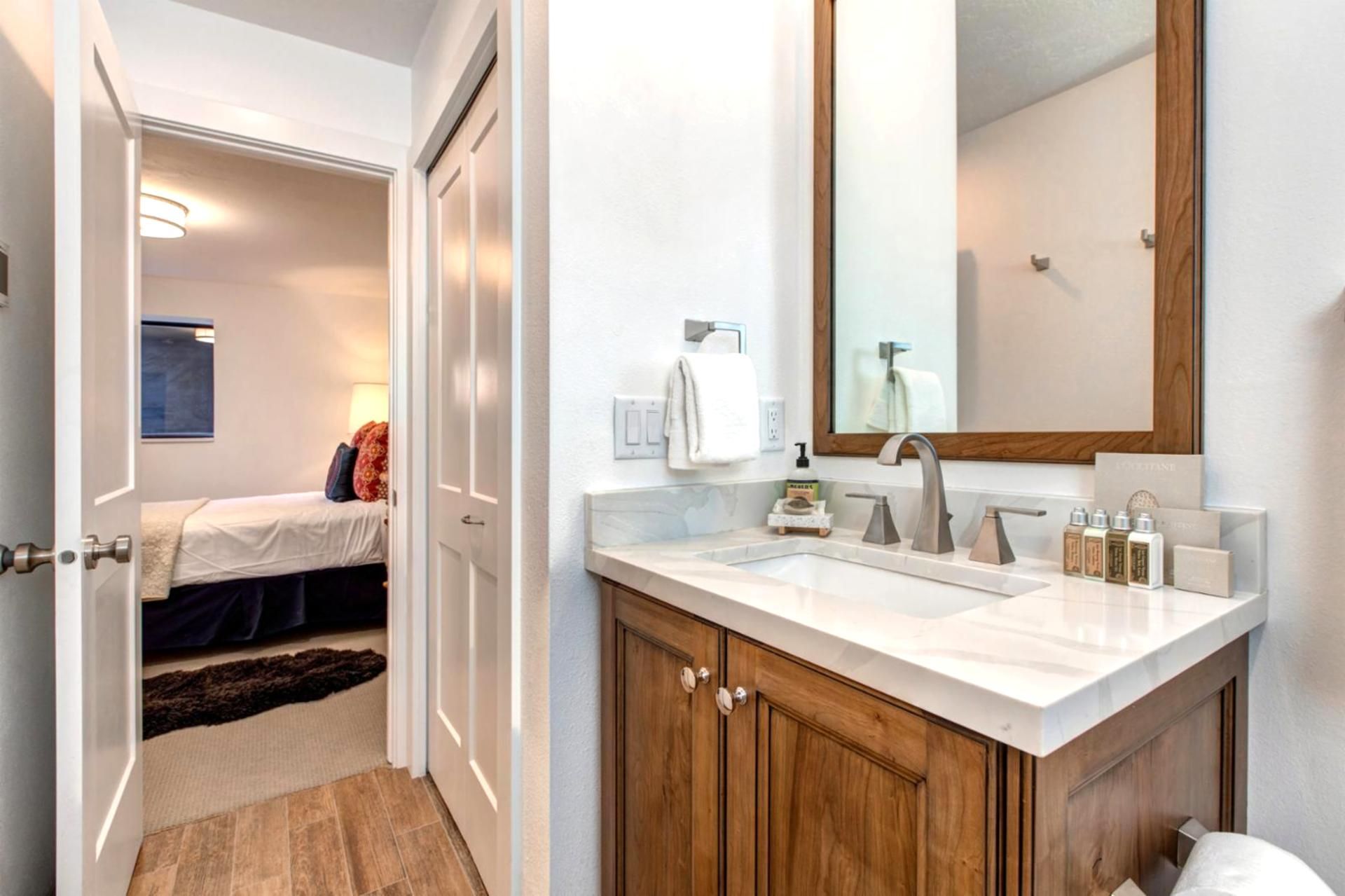 Une salle de bain moderne avec un grand miroir, un lavabo et des meubles en bois.