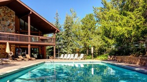 Una piscina con sillas de descanso y una terraza de madera.