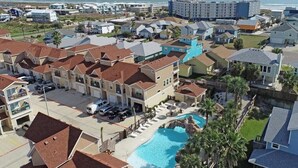 Un barrio residencial con casas, piscina y vista al océano.