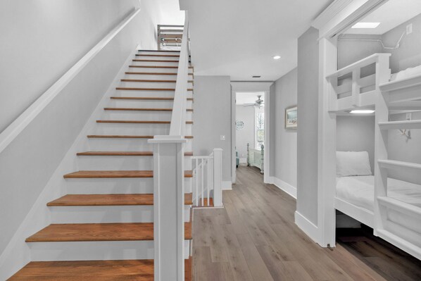 A staircase with wooden steps and white railings leading to a landing.