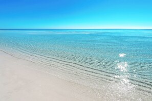 A beach with clear water and a sandy shore.