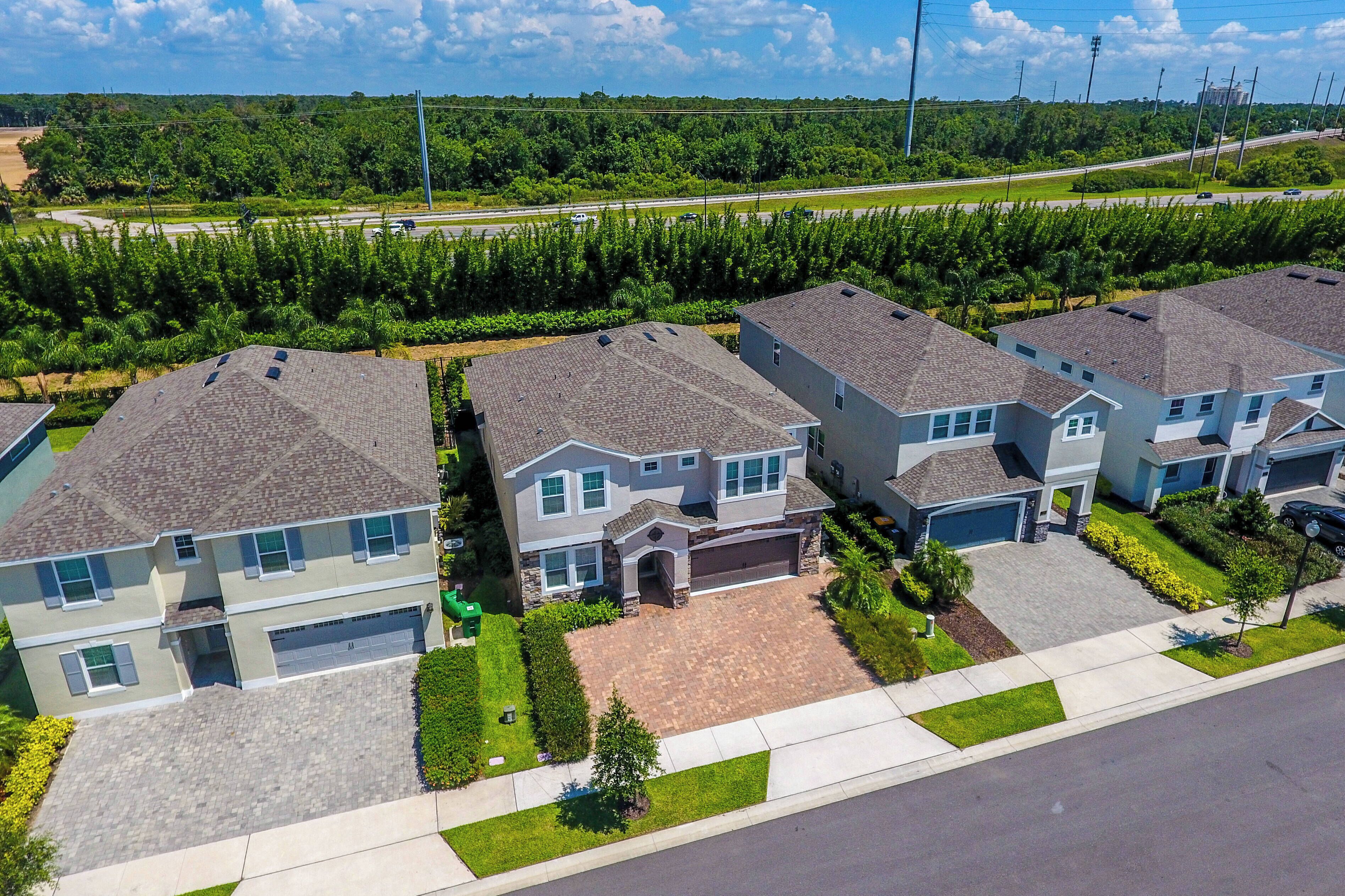 A residential area with modern houses featuring two-story structures, attached garages, and well-maintained lawns.