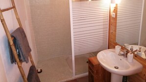 A bathroom with a shower, a sink, and a mirror.
