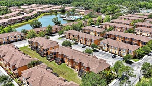 A residential area with apartment buildings, a body of water, and a dock. - Comfortable 4br w/ private jacuzzi (Kissimmee)