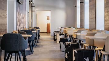 Un restaurant moderne avec un long comptoir, des chaises à motifs noir et blanc et des éléments décoratifs en bois sur les murs.