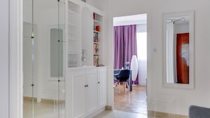 A modern interior with a glass-fronted wardrobe, a dining area with a purple curtain, and a mirror on the wall. - Fauriel Aimé - Prestations haut de gamme - St Etienne (Saint Etienne)