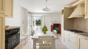 Une cuisine équipée d’une cuisinière, d’un four et d’une table à manger avec des chaises.