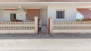 Un bâtiment à deux étages, doté d’un toit en tuiles, d’une entrée fermée par un portail et d’un escalier menant au deuxième étage.