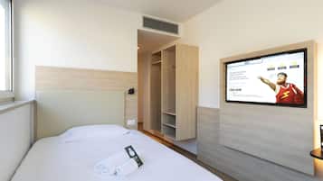 A hotel room with a bed, a TV mounted on the wall, and a wardrobe.