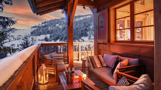 A wooden cabin with a balcony overlooking a snowy mountain landscape. - Chalet Cosyneige for 11 in La Clusaz, hot tub - OVO Network (La Clusaz)