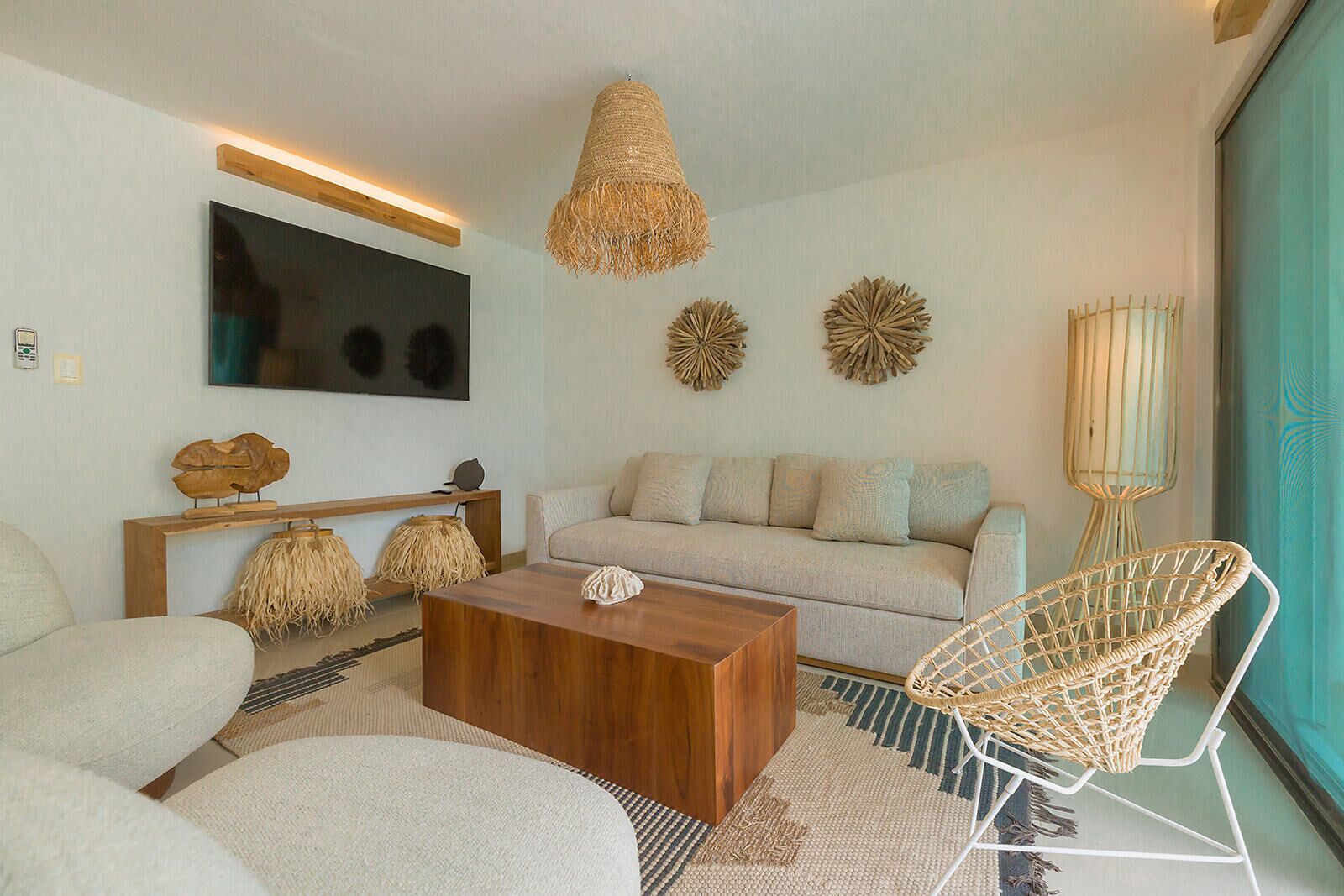 A modern living room with a sofa, coffee table, and wicker chair.