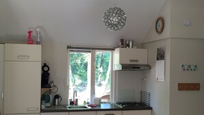 Une cuisine avec une fenêtre, un évier, une cuisinière et des placards.