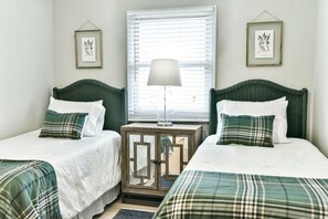A room with two beds, a nightstand, a lamp, and framed botanical prints on the walls. - Roomy 3 BR Condo Walkable to IU (Bloomington)