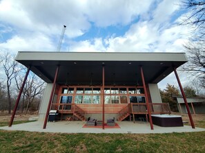 A modern building with a covered patio, large windows, and a wooden deck.