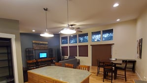 A spacious kitchen with wooden cabinets, a central island, and a dining area with chairs and a table. - Serene Lake Home (Fort Scott)