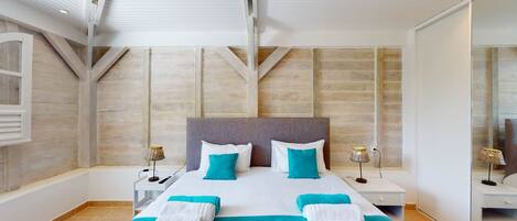 A modern bedroom with a large bed, two bedside tables, and a large mirror.