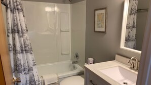 A bathroom with a bathtub, toilet, and sink. - 201 - Executive Rm Lake View- Balcony 2 DBL (Port Elgin)