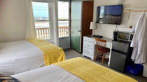 A hotel room with two beds, a desk, a chair, a television, and a refrigerator. - 201 - Executive Rm Lake View- Balcony 2 DBL (Port Elgin)