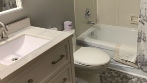 A bathroom with a white sink, toilet, and bathtub.