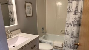 Un baño con lavamanos, inodoro y bañera.