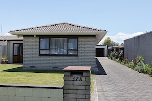 A single-story house with a tiled roof, a brick facade, and a small front yard.