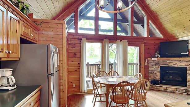 Een houten cabin met keuken, eethoek en open haard.