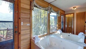 Une cabane en bois avec une grande baignoire et vue sur la forêt.