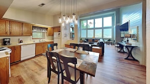 Une cuisine spacieuse avec des meubles de rangement en bois et un coin repas comprenant une table et des chaises en bois.