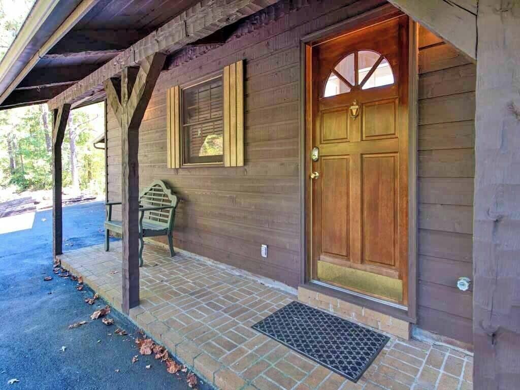A wooden building with a large wooden door and a bench outside.