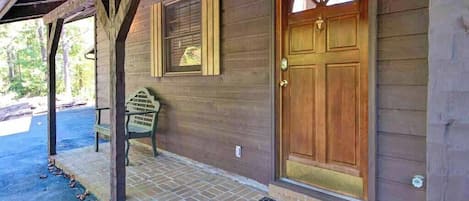 A wooden building with a large wooden door and a bench outside.