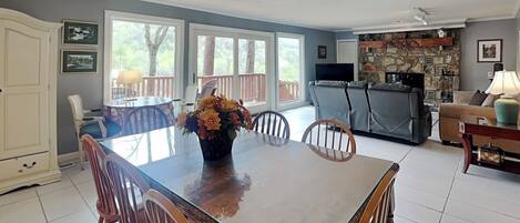 A dining area with a wooden table, chairs, and a vase of flowers.
