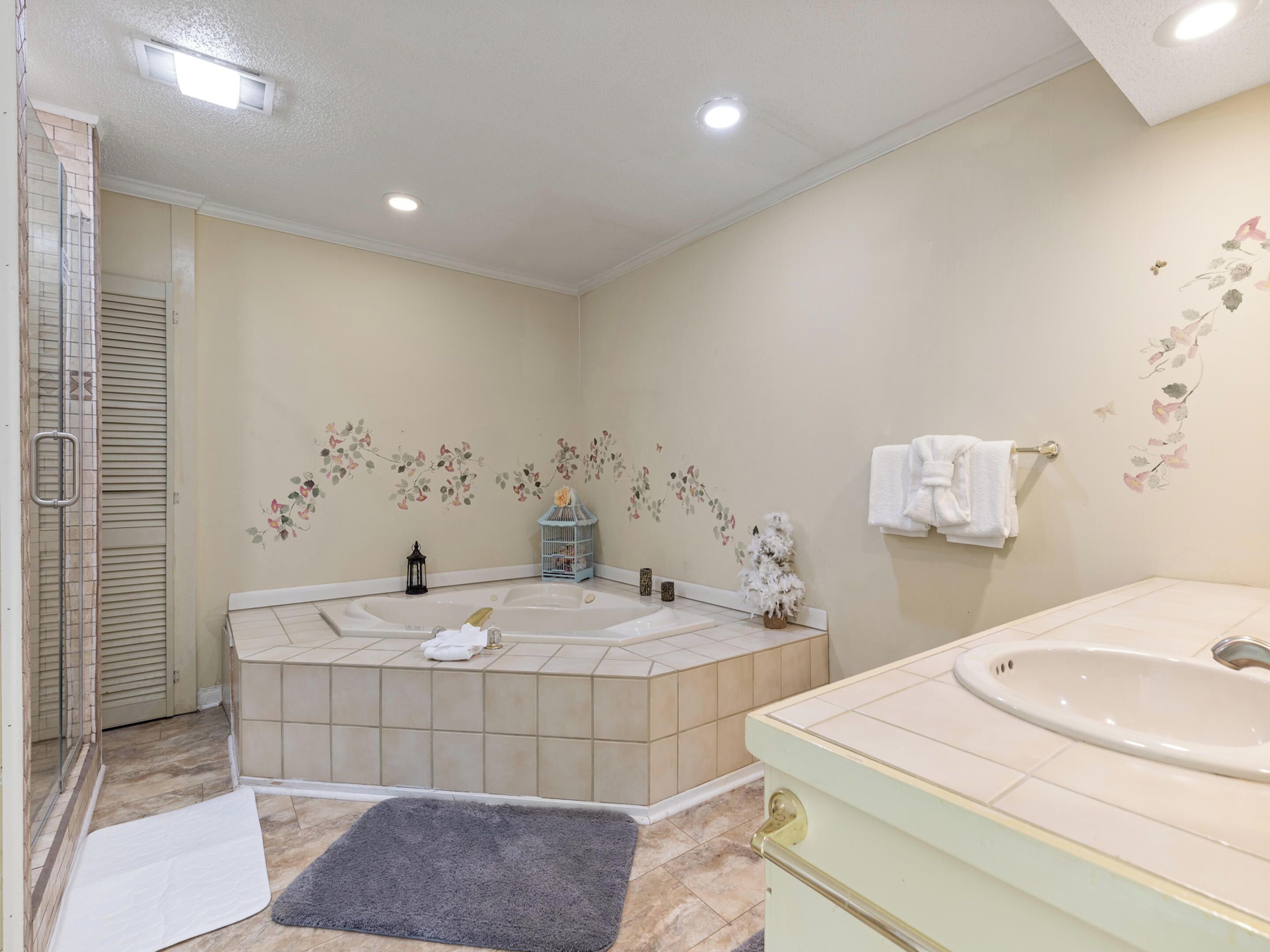 A bathroom with a bathtub, a sink, and a shower area.