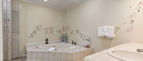 A bathroom with a bathtub, a sink, and a shower area.