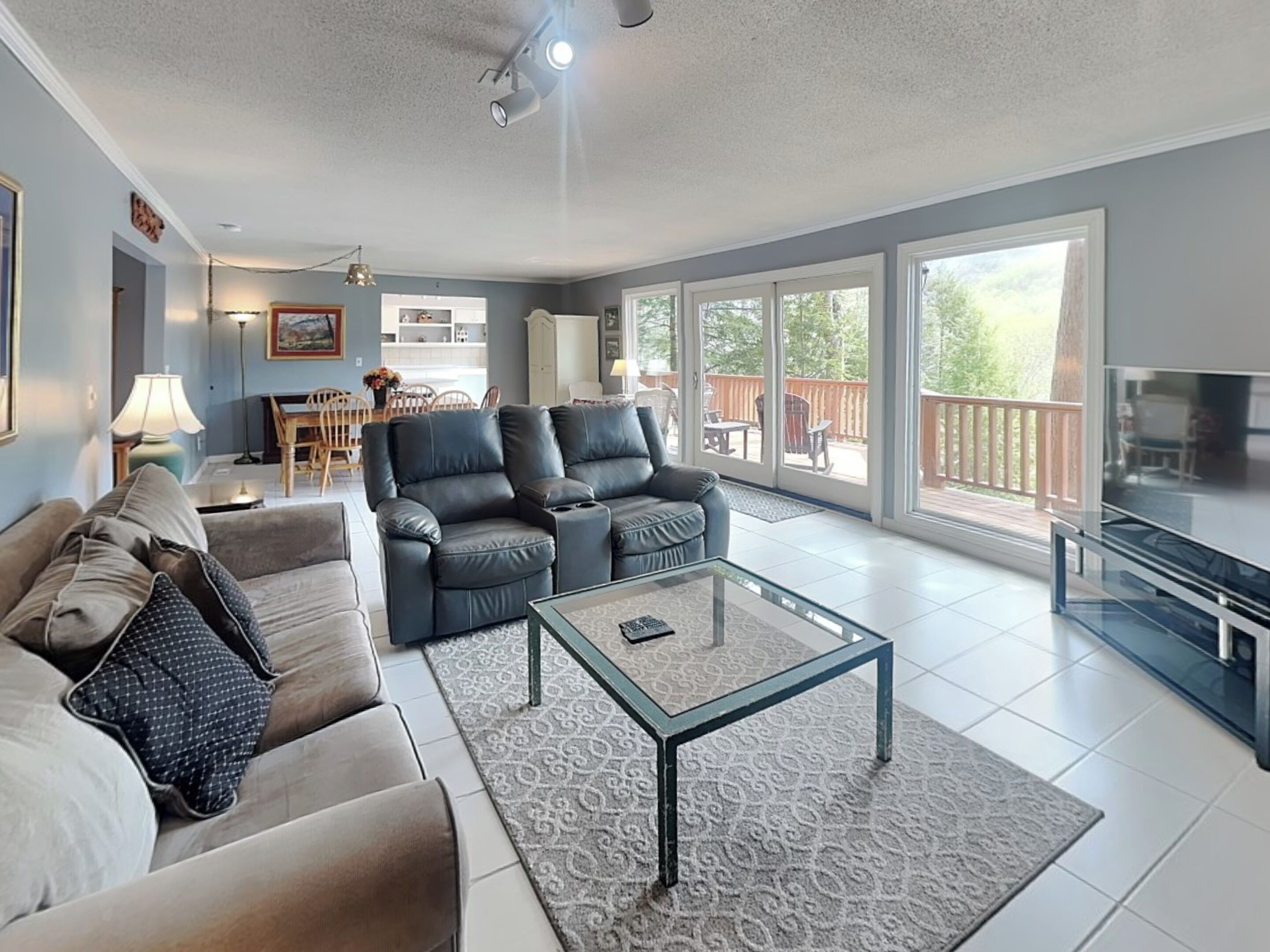 A spacious living room with a sofa, a coffee table, and a TV.
