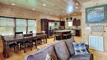 A cozy cabin interior with a dining area, kitchen, and living room.