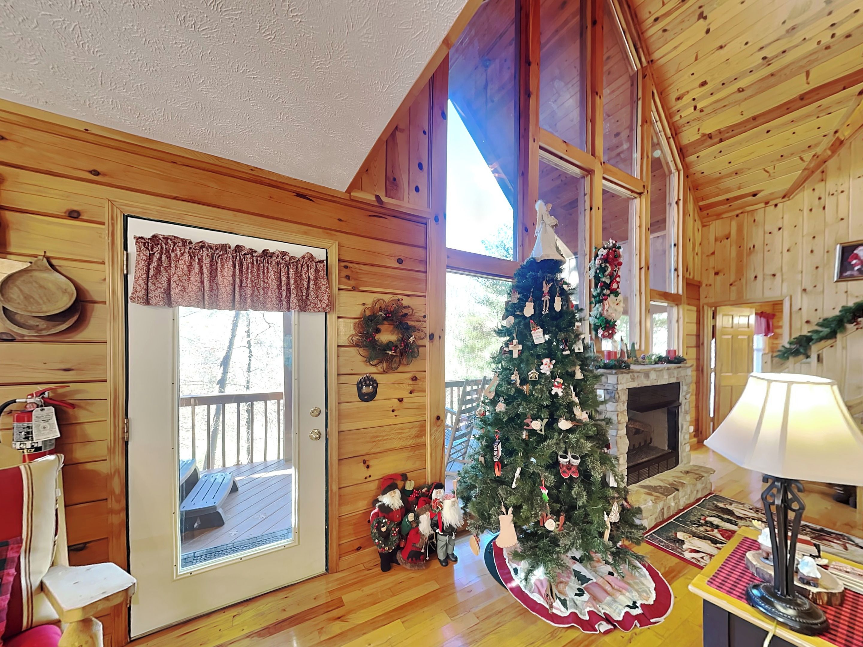 L’intérieur chaleureux d’un chalet, avec un décor en bois, un sapin de Noël et une cheminée.