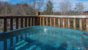 A hot tub with a wooden deck and a clear blue sky in the background. - Mountain View Lodge by Jackson Mountain Rentals (Gatlinburg)